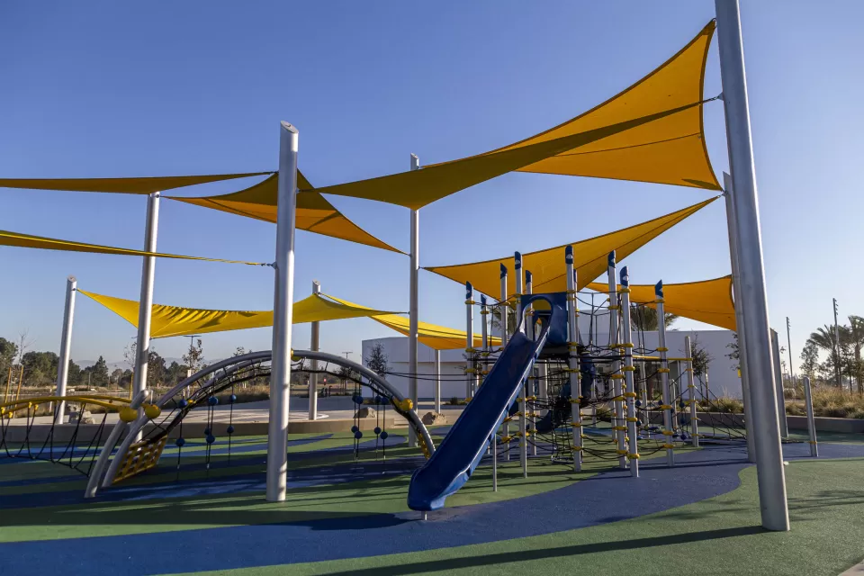 Playground with yellow shade sails and blue equipment in Los Angeles, California